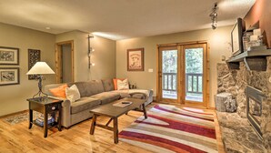 A cozy living room with a sofa, coffee table, and fireplace.