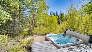 A hot tub in a forested area with a wooden deck. - Mountain Home ~ 5 Mi to Winter Park Resort! (Winter Park)