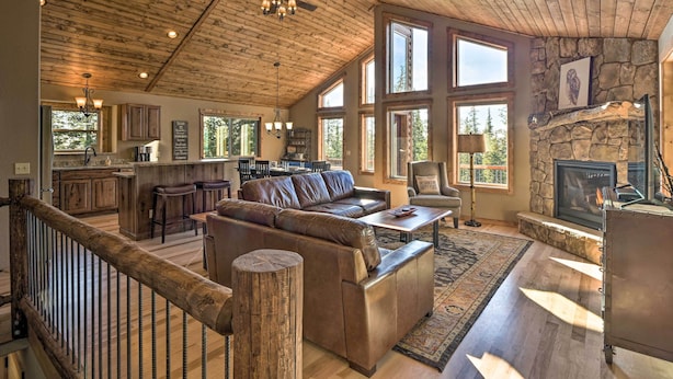 A spacious living area with a wooden ceiling, stone fireplace, and large windows. - Fairplay Dream Escape: 27 Miles to Breckenridge! (Fairplay)