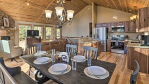 A spacious kitchen with wooden cabinets, a large island, and a dining area set for four. - Fairplay Dream Escape: 27 Miles to Breckenridge! (Fairplay)