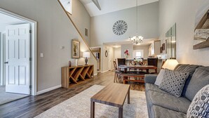A spacious living area with a staircase, a dining table, and a sofa. - Lakefront Branson Penthouse w/ Resort Amenities! (Branson)