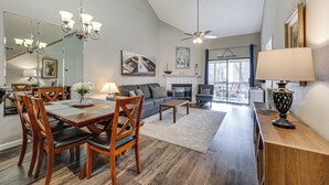 A spacious living room with a dining area, a fireplace, and a large mirror. - Lakefront Branson Penthouse w/ Resort Amenities! (Branson)