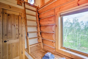 A wooden interior with a ladder, a window with a view of trees, and a door. - 22str-00506 Fairplay Log Cabin: 26 Mi to Breck! (Fairplay)