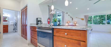 A modern kitchen with a large island, wooden cabinets, and a built-in oven.