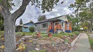 A two-story house with a front porch, a red door, and a small staircase leading to the entrance. - Comfy & Cozy Kalispell Home: Walk to Downtown (Kalispell)