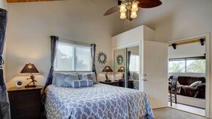 A bedroom with a bed, nightstands, lamps, and a ceiling fan. - Cozy Kona Coast Apt w/ Lanai ~ 8 Miles to Beach! (Kailua-Kona)