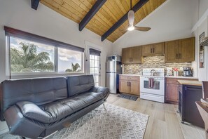 A modern kitchen with wooden cabinets, a stainless steel refrigerator, and a built-in oven. - Cozy Kona Coast Apt w/ Lanai ~ 8 Miles to Beach! (Kailua-Kona)