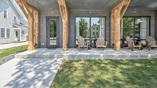 A modern house with a covered porch, large windows, and outdoor seating. - Elkhart Lake Townhome - 3 Mi to Road America! (Elkhart Lake)