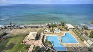Un complexe hôtelier doté d’une piscine, d’une plage et offrant une vue sur l’océan.
