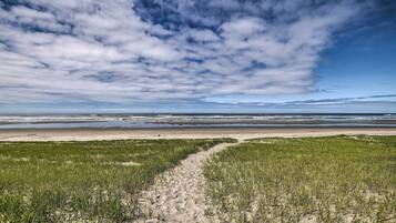 Stroll along the beach, where a grassy path leads to the shore.