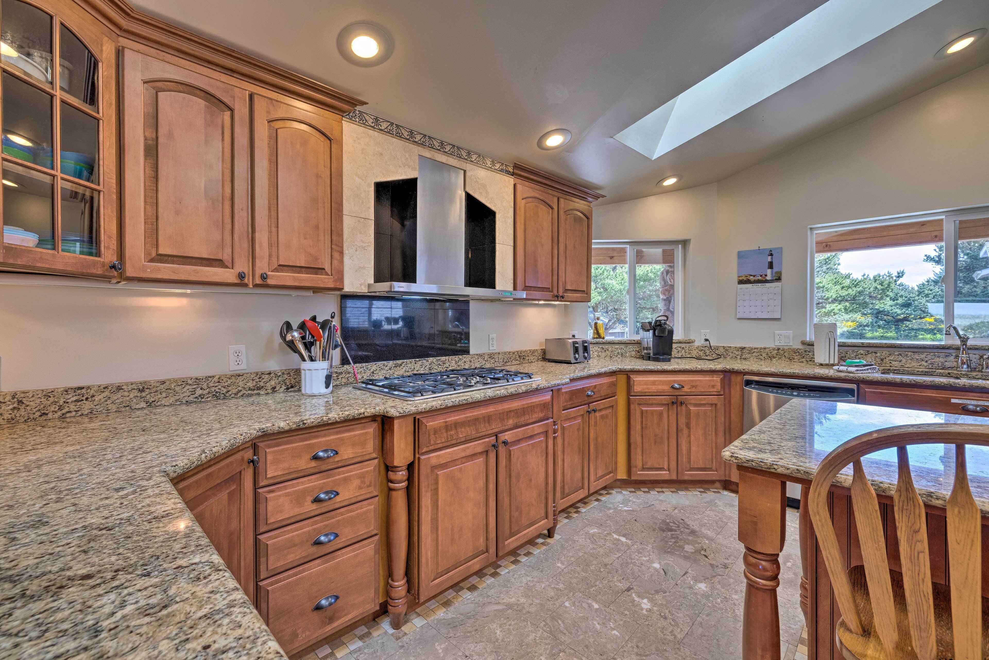 A kitchen with granite countertops, wooden cabinets, a stainless steel range hood, and a dishwasher.