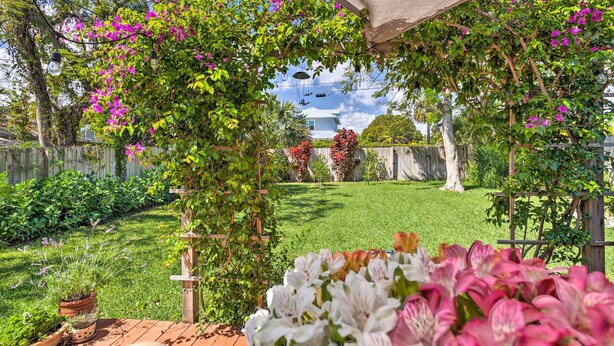 A garden with a pergola, potted plants, and a lawn. - West Palm Beach Home w/ Fenced-in Yard & Deck! (West Palm Beach)