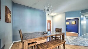 Ein Essbereich mit Holztisch und Bänken, einer Kristallleuchtre und einer blauen Wand.