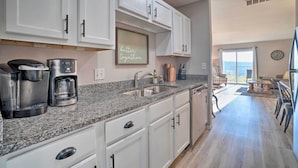 A modern kitchen with white cabinets, a granite countertop, and a coffee maker. - Sunny Family-friendly Branson Home! (Branson)