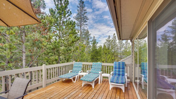 A wooden deck with four lounge chairs and a table, overlooking a forested area. - Sunriver Getaway w/ Sharc Waterpark Passes! (Bend)