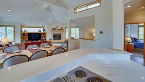A spacious living area with a dining table, kitchen island, and seating. - Sunriver Getaway w/ Sharc Waterpark Passes! (Bend)