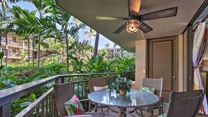 A balcony with a glass table, chairs, and a ceiling fan. - Kailua-kona Condo w/ 2 Private Lanais! (Kailua-Kona)