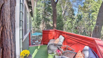 Relax in a serene outdoor seating area surrounded by trees with a view of the surrounding forest.