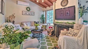 Un salon chaleureux avec une cheminée, des fauteuils confortables et un téléviseur.