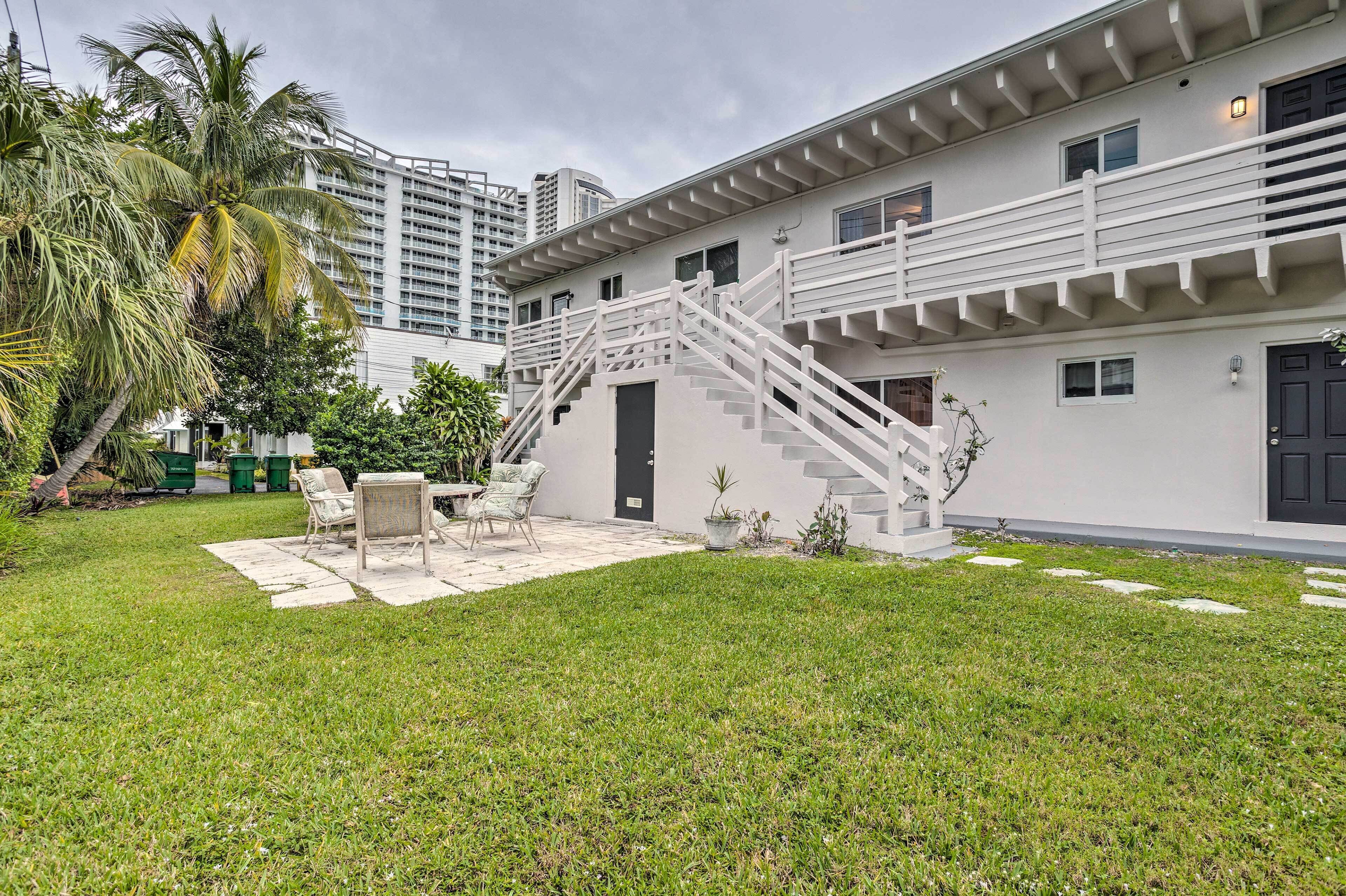 A modern building with a white exterior, a staircase, and a patio area with outdoor furniture.