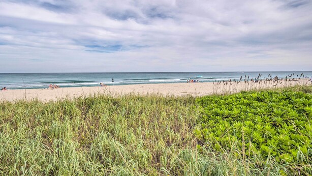 A beach with a grassy foreground and a clear sky. - Cozy West Palm Beach Condo: 1 Block to Shore! (Singer Island)