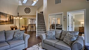 A spacious living room with two grey sofas, a chandelier, and a staircase leading to an upper level. - 5 Mi to Dtwn & Strip! Branson Condo w/ Indoor Pool (Branson)