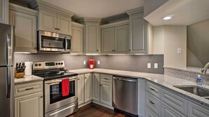 A modern kitchen with stainless steel appliances, light grey cabinetry, and a granite countertop. - 5 Mi to Dtwn & Strip! Branson Condo w/ Indoor Pool (Branson)