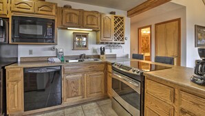 A kitchen with wooden cabinetry, a built-in microwave, a dishwasher, and an oven. - Resort Perks & Trail Access: Silverthorne Condo! (Silverthorne)