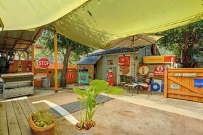 A roadside convenience store with various signs, including a stop sign, and a gas pump. - San Antonio Tiny Home, 4 Mi to Brackenridge Park (San Antonio)