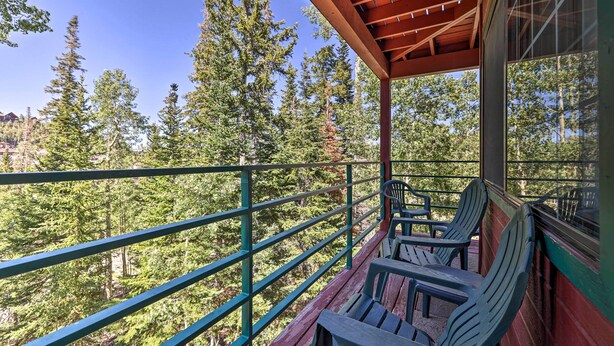 A balcony with wooden railings and two chairs, overlooking a forested area. - Slopeside Condo With Hot Tub + Game Room Access! (Brian Head)