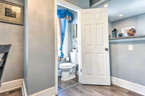 A bathroom with a toilet, a shower curtain, and a white door.