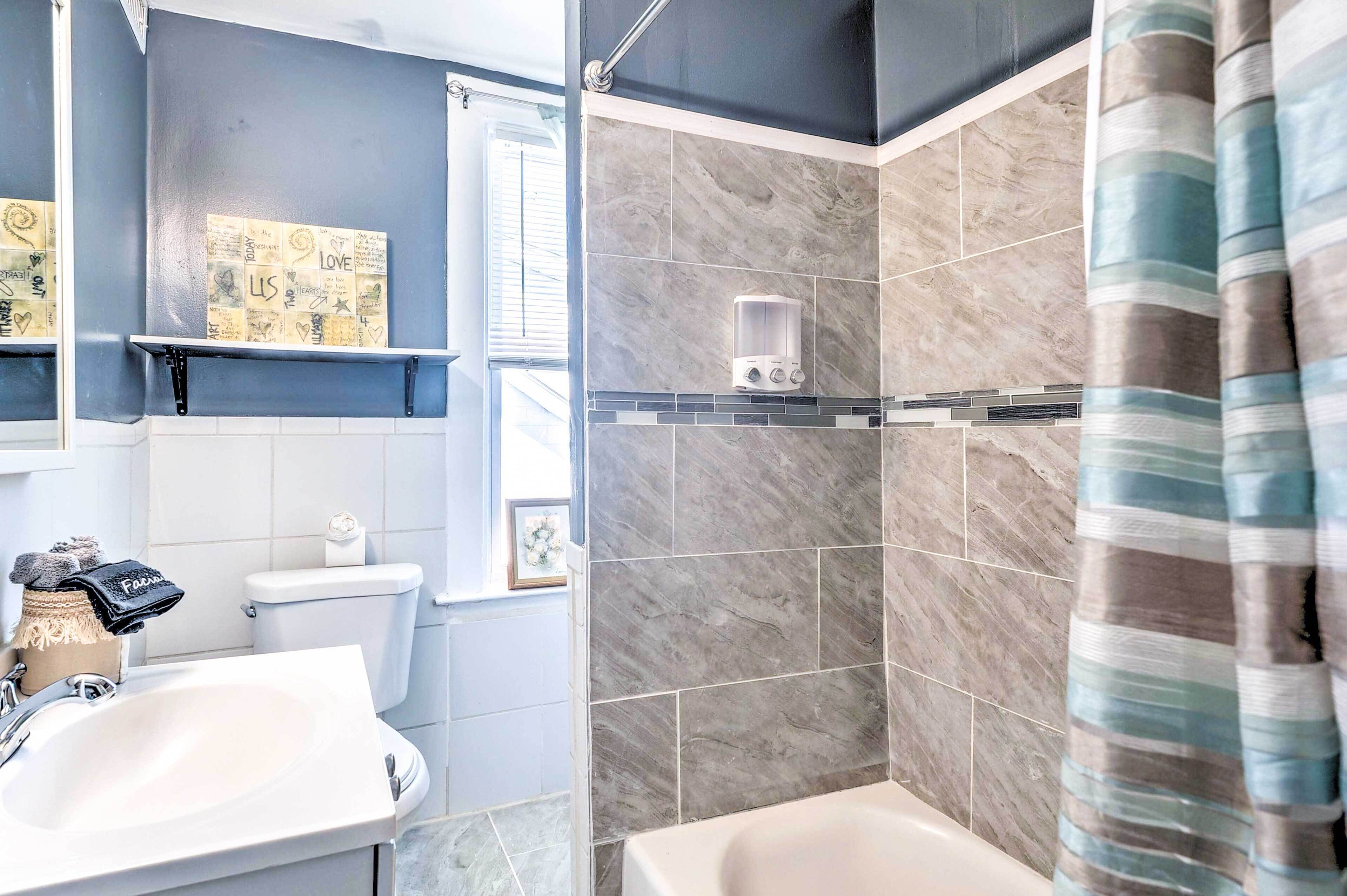 A bathroom with a white sink, a toilet, a shower with a glass enclosure, and a towel rack with a towel.