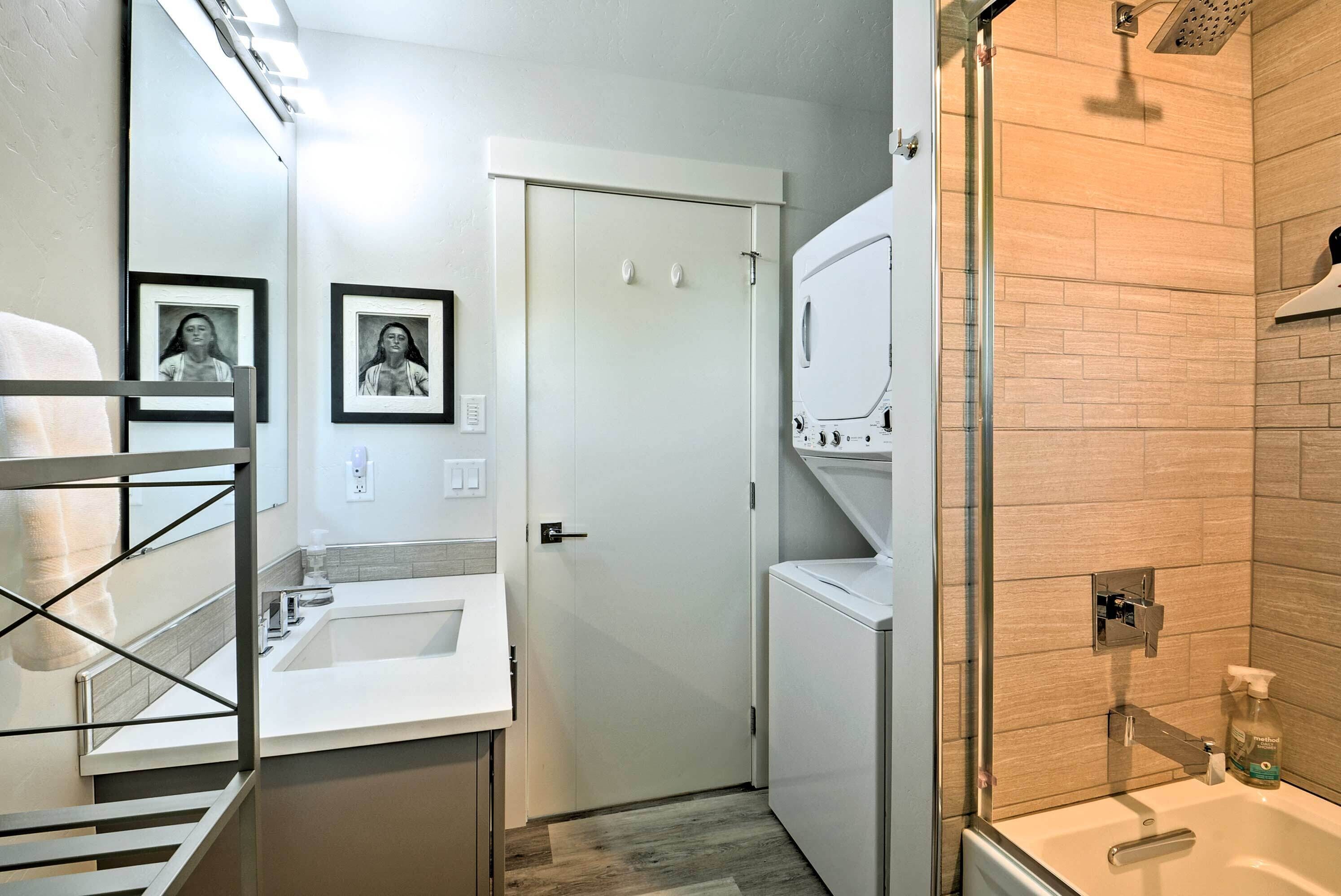Un baño pequeño con lavamanos, espejo y zona de ducha.