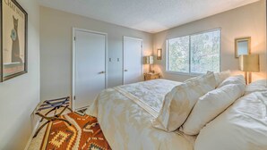 Ein Schlafzimmer mit Bett, Fenster, Tür und Teppich.