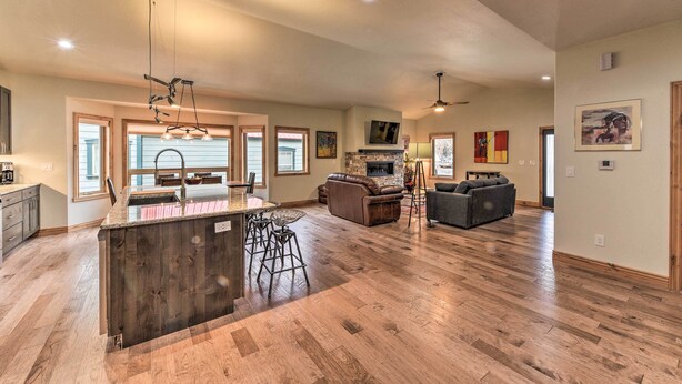 A spacious living area with a kitchen island, bar stools, a fireplace, and a large couch. - Charming Buena Vista Home ~ 1 Block to Main Street (Buena Vista)