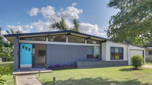 A modern two-story house with a blue door, large windows, and a well-maintained lawn. - Bright & Modern Texas Getaway - 7 Mi to The Alamo! (San Antonio)