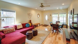 A spacious living room with a red sectional sofa, wooden flooring, and a ceiling fan. - Buena Vista 'shambala' Sanctuary Near Main St! (Buena Vista)