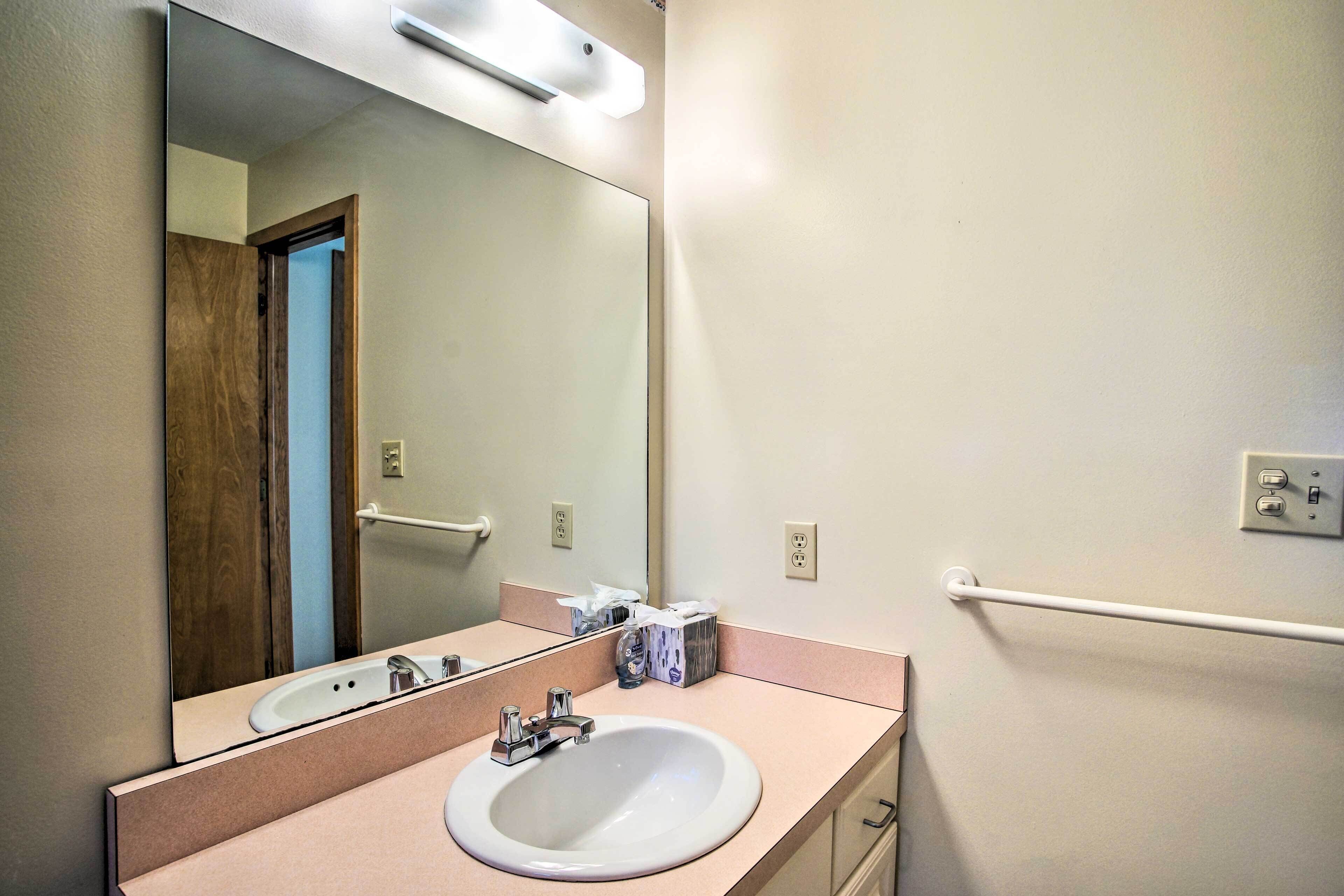 Une salle de bain avec un lavabo blanc, un miroir et un porte-serviettes.
