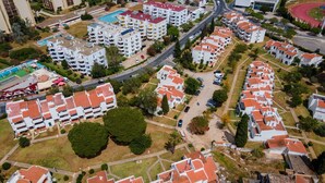 Vue aérienne d’un quartier résidentiel comprenant plusieurs immeubles d’appartements, des routes et une piste d’athlétisme.
