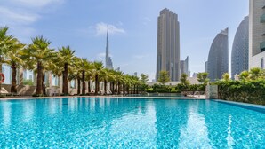 Una piscina con palme e moderni edifici sullo sfondo.