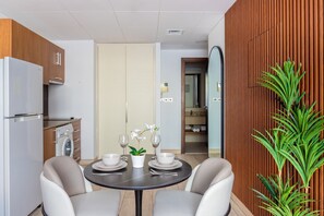 Una cocina moderna con comedor, que incluye refrigerador, horno, lavaplatos y armarios de madera.