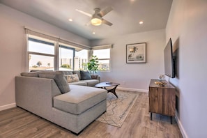 Relax in this stylish living room with a sofa, coffee table, and large windows offering a city view.