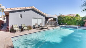 Una casa moderna amb piscina, terrassa coberta i garatge.