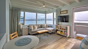 A modern living room with a sofa, TV, and a view of the water. - Chic Bay View Condo < 10 Miles to Dtwn San Diego! (San Diego)