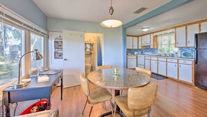 A kitchen with a round table, chairs, a refrigerator, and cabinets. - Riverfront St Augustine Retreat, Near Boat Launch! (St. Augustine)