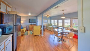 A spacious kitchen with a refrigerator, dining table, and chairs. There is a television mounted on the wall and a window providing natural light. - Riverfront St Augustine Retreat, Near Boat Launch! (St. Augustine)