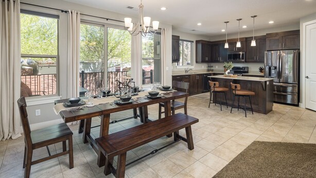 Una cocina moderna con armarios de madera oscura, una isla grande y un comedor con banco.