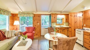 Un acogedor interior de cabaña con sala de estar, comedor y cocina.