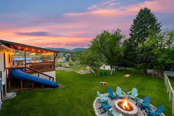 The large, fenced backyard has plenty of room, a tube slide, fire pit, and kid's play set. Have fun!