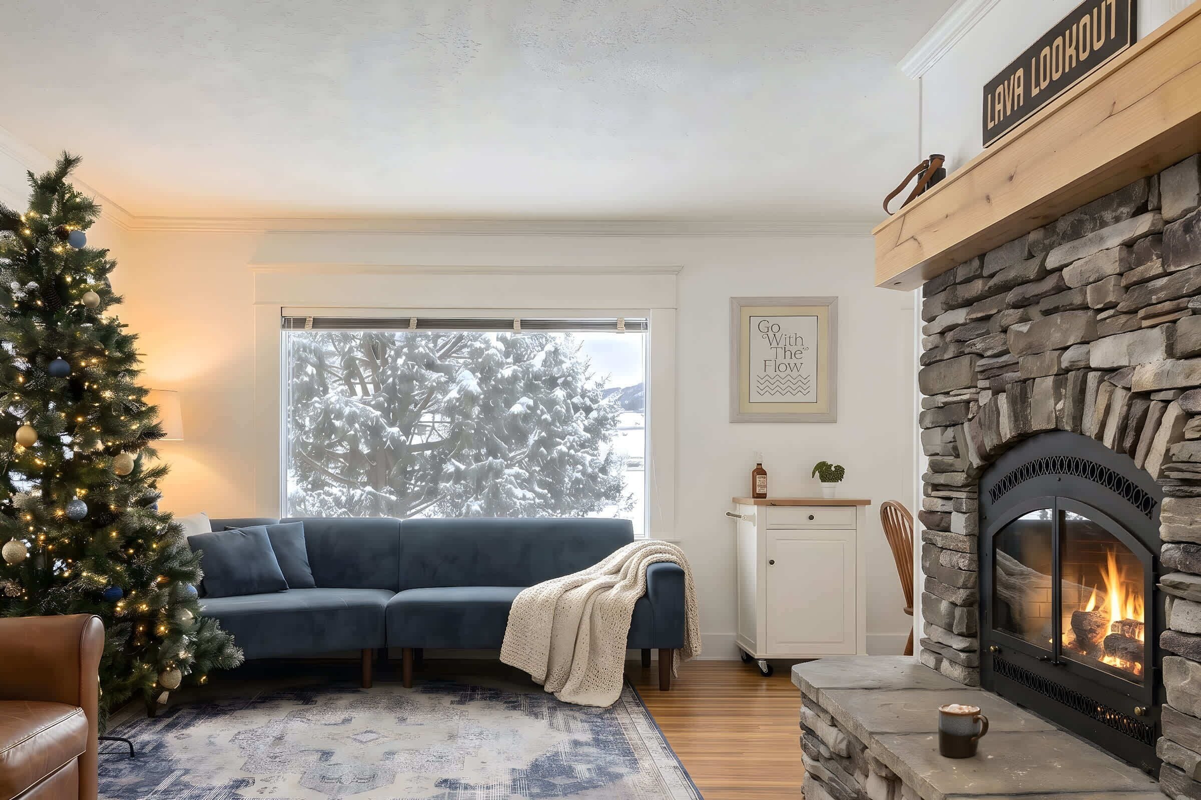 Una sala acogedora con chimenea, árbol de Navidad y sofá azul.